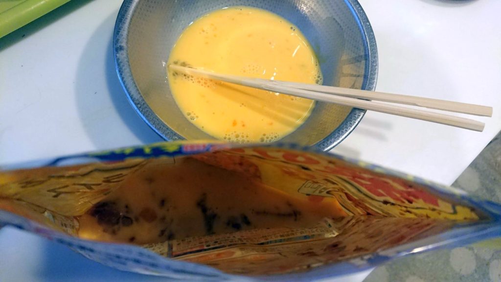 日本ハム「袋のままできるオムライス」に溶き卵を流し入れる。